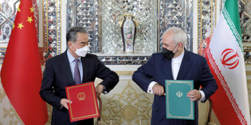Iranian Foreign Minister Mohammad Javad Zarif, right, and his Chinese counterpart, Wang Yi, pose for a photo after signing a bilateral agreement, in Tehran, Iran, March 27, 2021. Source: voanews.com