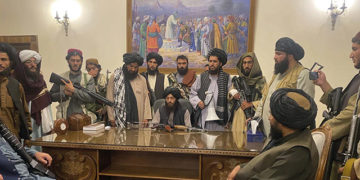 Taliban militants and leadership hold a meeting in a government office after seizing power. Photo by Zabi Karimi/AP