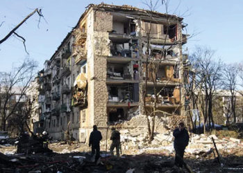 Ukrainians beside a building hit by Russian shelling in a residential area of Kyiv. By Vladyslav Musiienko/UPI/REX/Shutterstock