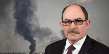 Prof. Col. David Johnson pictured on a background of fighting in Sievierodonetsk, Ukraine. Aris Messinis/AFP via Getty Images