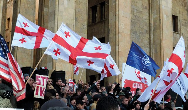 Protesters waving flags in front of Georgian Parliament. Photo by Sharon De Graeve (2019)