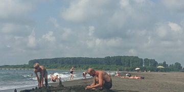 A Russian family builds a sandcastle on a Georgian beach. Photo by Katie Ruth Davies