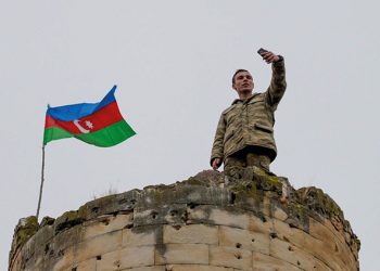 An Azerbaijani soldier takes a photo on top of a tower in Nagorno-Karabakh. Source: AFP Photo