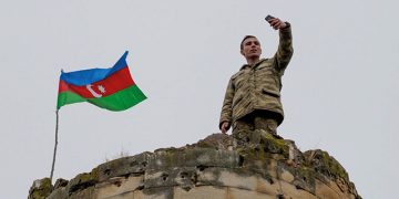 An Azerbaijani soldier takes a photo on top of a tower in Nagorno-Karabakh. Source: AFP Photo