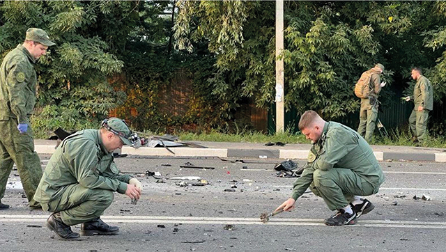 Russian investigators sift through the vehicle pieces looking for clues after the bombing attack on Daria Dugina. Source: Reuters