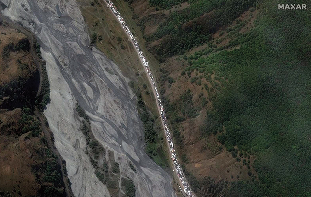 Satellite imagery showing the line of vehicles and foot traffic making their way through the Caucasus mountains into Georgia. Satellite image from Maxar Technologies