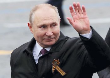 Russian President Vladimir Putin waves while walking along Red Square. Photo by Evgenia Novozhenina/Reuters