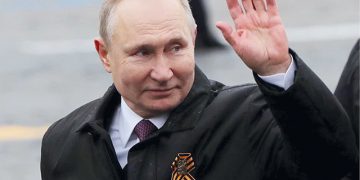 Russian President Vladimir Putin waves while walking along Red Square. Photo by Evgenia Novozhenina/Reuters