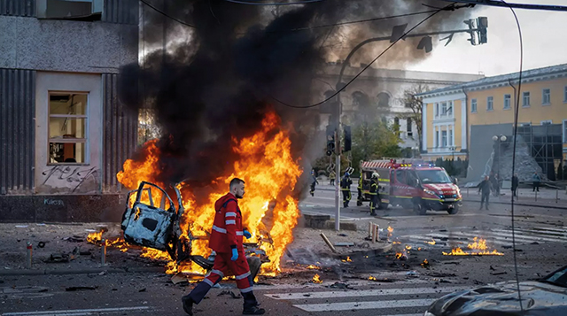 A medical worker passes a burning car after a Russian attack in Kyiv, Ukraine. Source: AP / Roman Hrytsyna)