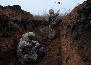 Two soldiers with the 58th Independent Motorized Infantry Brigade of the Ukrainian army release a drone on the outskirts of Bakhmut. Photo by Leah Millis/Reuters