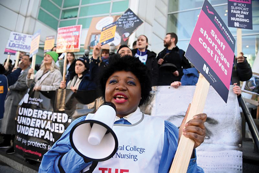 A person uses a megaphone as nurses protest during a strike by NHS medical workers in February. Photo by Toby Melville / REUTERS