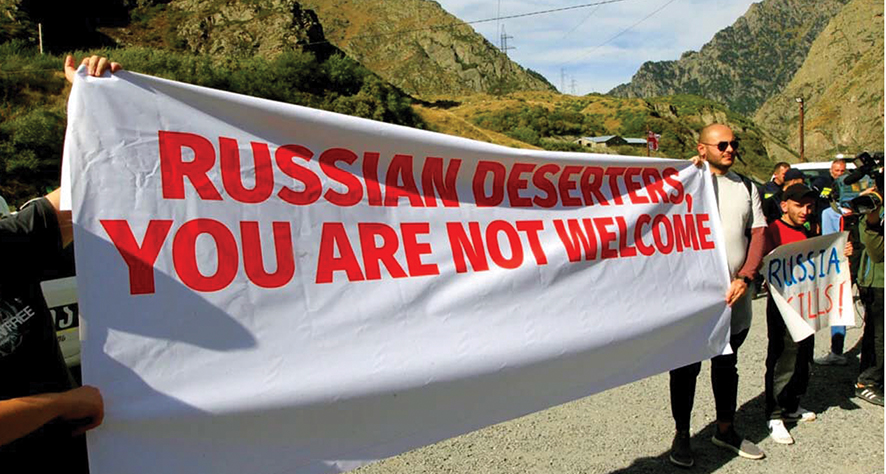 Activists hold an anti-Russian banner during an action organized by political party Droa near the border crossing at Verkhny Lars between Georgia and Russia in Georgia, Sept. 28, 2022. Some Georgians have voiced concerns about the exodus of Russians into their country. Source: VOA