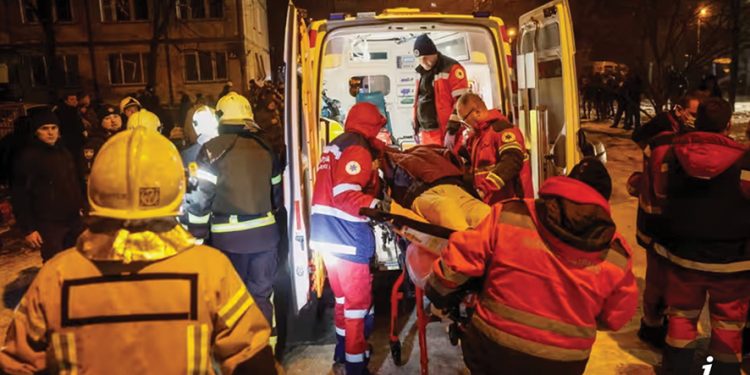 Medics carry a wounded person after an apartment building was damaged during a Russian missile strike in Kyiv. Photo by Gleb Garanich/Reuters
