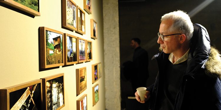 An attendee of the opening night of the exhibition examines one of the displays. Image by Shako Devdariani