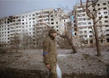 Ukrainian soldier walks past destroyed buildings after attacks in the city of Orichiv, Zaporizhzhia. Source: Anadolu/Getty Images