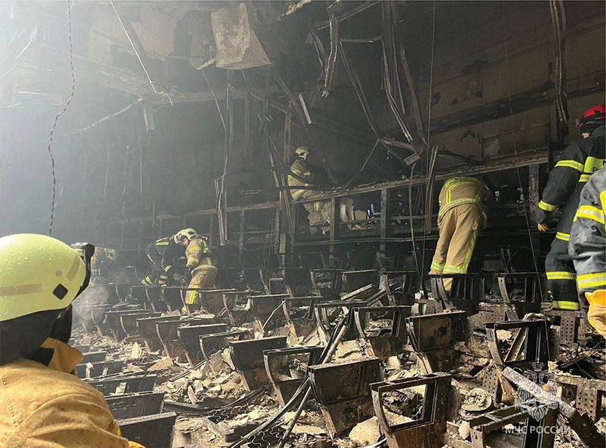 Russian emergency services sift through the burnt wreckage of the entertainment center. Source: Russian Emergency Ministry Press Service via AP