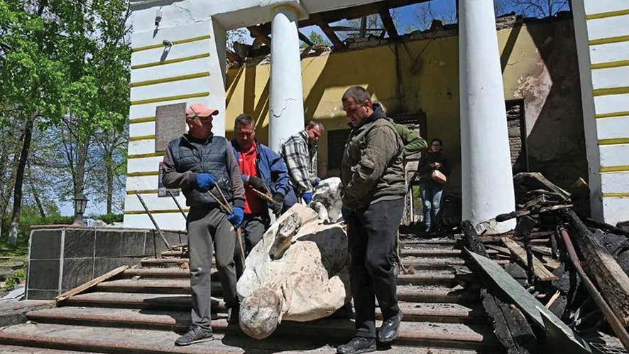 Workers salvage a sculpture of Hryhoriy Skovoroda from his destroyed museum in May 2022. Sergey Bobok/AFP