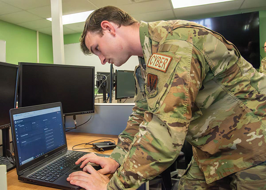 US Air Force Senior Airman Michael Gavin, 140th Cyber Warfare Operator, presents at the 140th Cyber Operations Squadron Open House. US Air Force Photo by Tech. Sgt. Anna-kay Ellis