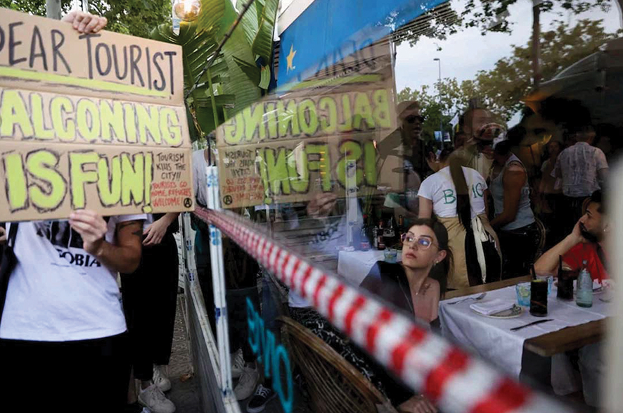 A tourist watches as demonstrators protest against mass tourism in Barcelona, Spain. Source: REUTERS/Bruna Casas