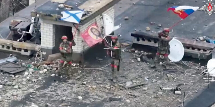 A drone view shows Russian service members waving flags on the roof of a building in the settlement of Velyka Novosilka in the Donetsk region, a Russian-controlled part of Ukraine. Source: Russian Defense Ministry/Handout