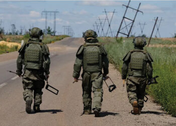 Russian armed forces walk along a motorway as they search for explosives and demine an area near the town of Maryinka, in the Russian-controlled Donetsk region of Ukraine, on June 24. Photo by Alexander Ermochenko/Reuters