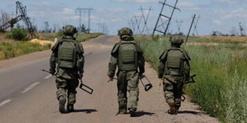 Russian armed forces walk along a motorway as they search for explosives and demine an area near the town of Maryinka, in the Russian-controlled Donetsk region of Ukraine, on June 24. Photo by Alexander Ermochenko/Reuters