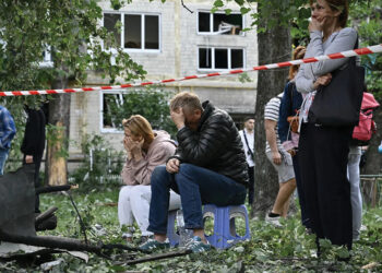 Local residents look on as rescuers conduct search and rescue work in a heavily damaged residential building following the Russian missile strike in Kyiv, Ukraine on June 17. Photo by Genya Savilov/AFP via Getty Images