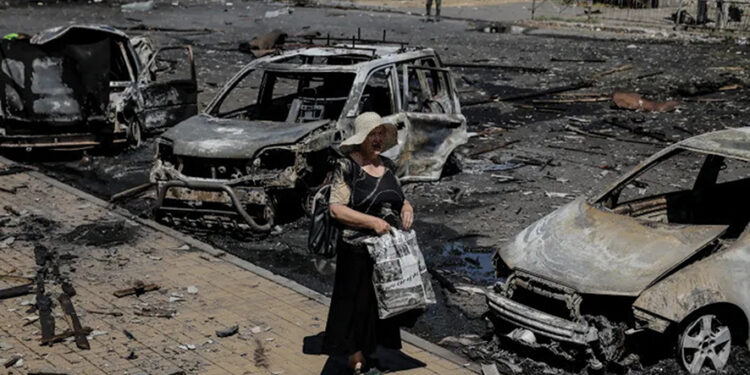 A resident stands next to burned cars hit by a Russian drone attack, in the town of Druzhkivka, Donetsk region, Ukraine. Photo by Oleg Petrasiuk- Press Service of the 24th King Danylo Separate Mechanised Brigade of the Ukrainian Armed Forces/Handout via Reuters