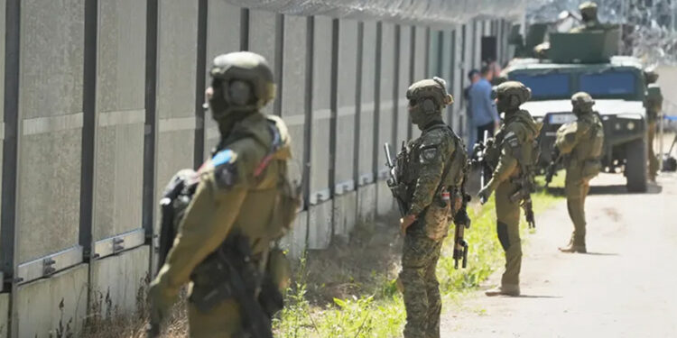 Polish border guard officers stand at the Poland-Belarusian border in July. Photo by Czarek Sokolowski/AP