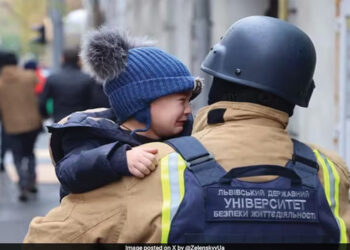 Ukrainian firefighter rescuing a child from the damaged kindergarten. Photo posted on X by @ZelenskyUa
