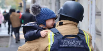 Ukrainian firefighter rescuing a child from the damaged kindergarten. Photo posted on X by @ZelenskyUa
