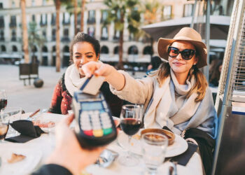 Tourists paying at a restaurant. Source: thepointsguy