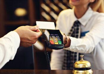 Man paying at a hotel. Source: Business Insider Magazine