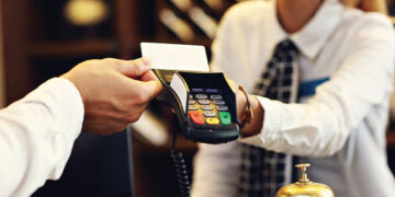 Man paying at a hotel. Source: Business Insider Magazine