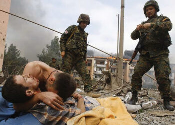 A Georgian man cries over the body of his relative after a Russian warplane dropped a bomb on the Georgian town of Gori. Photo by Gleb Garanich/Reuters