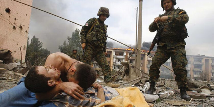 A Georgian man cries over the body of his relative after a Russian warplane dropped a bomb on the Georgian town of Gori. Photo by Gleb Garanich/Reuters